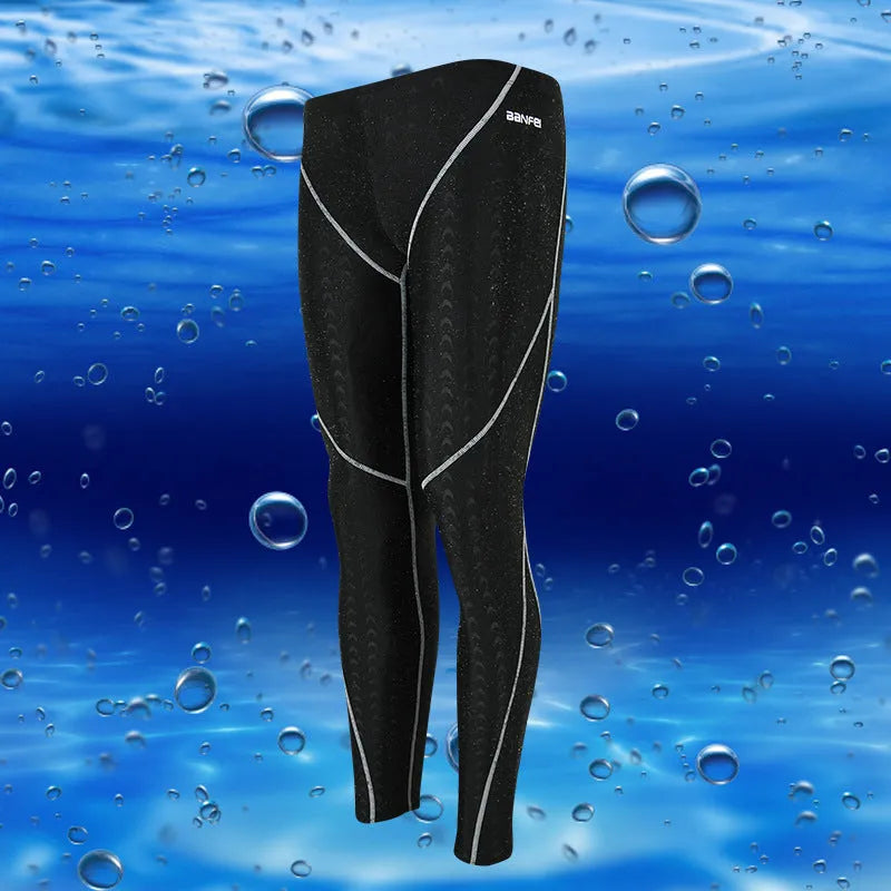 Men's nylon cropped swimming trunks in a black and green colour block design, laid flat.