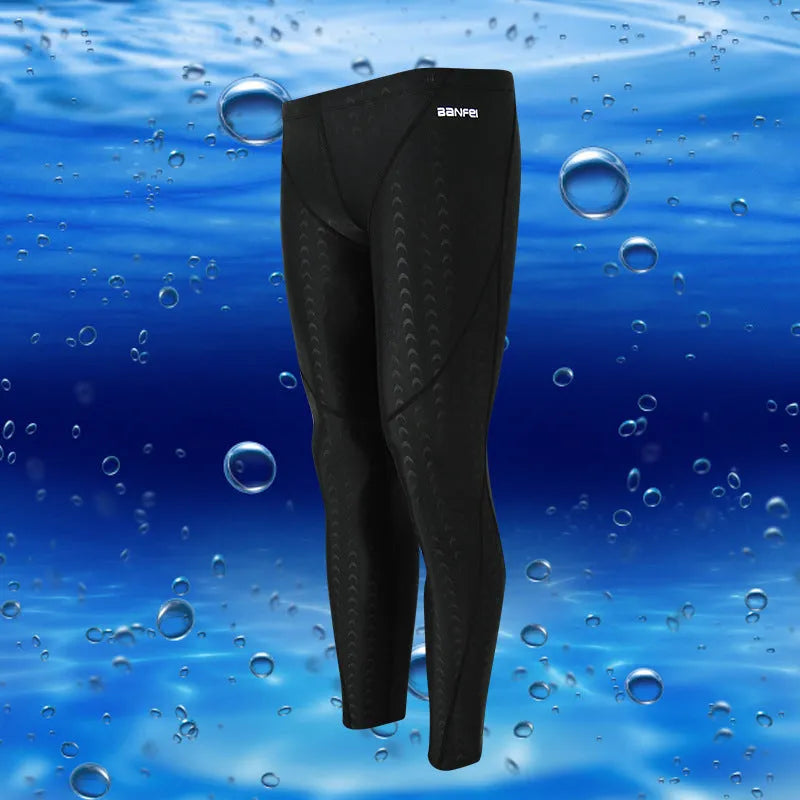 Men's nylon cropped swimming trunks in a black and green colour block design, laid flat.