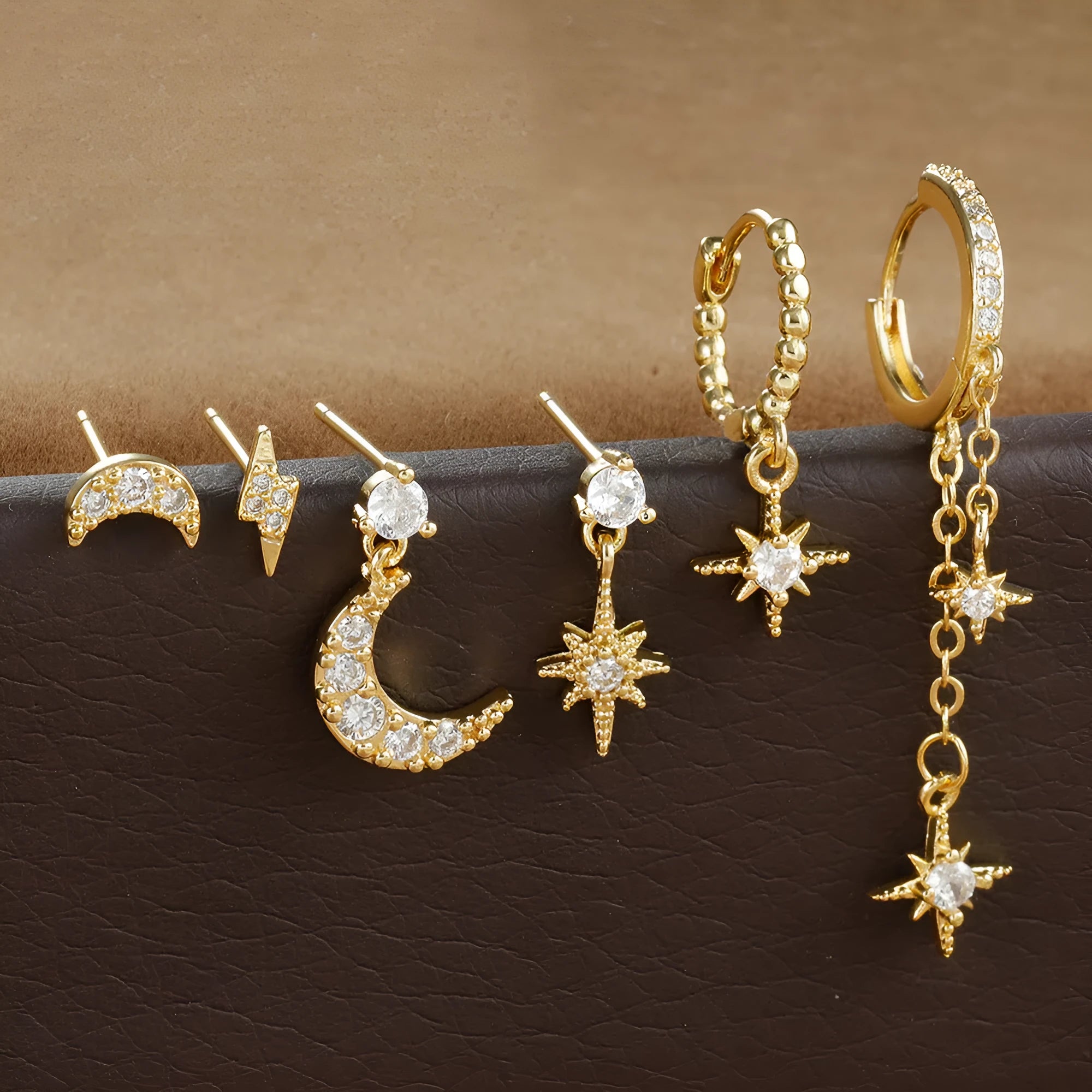 Six gold-colour chain tassel earrings with zircon detail arranged as a complete set