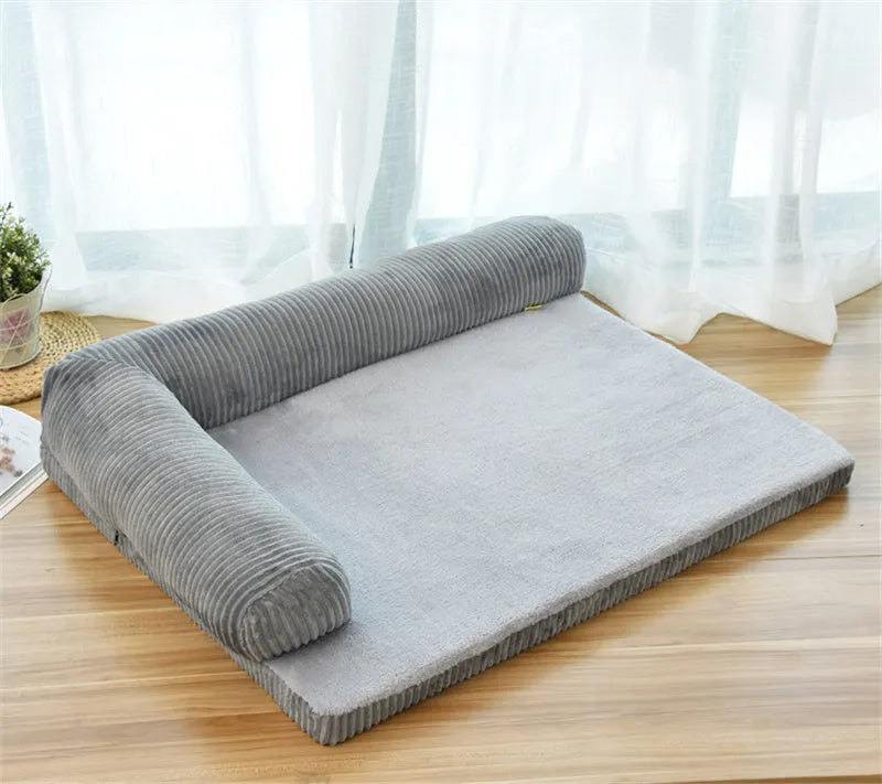 Corduroy pet sofa dog bed with bolster sides, shown in grey colour on a wooden floor