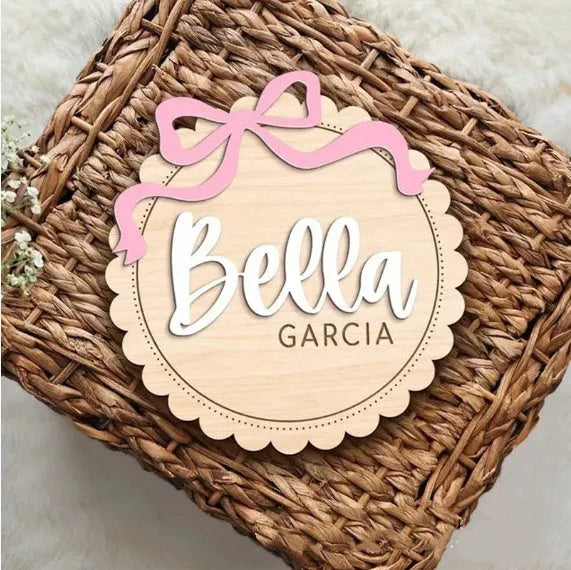 Square wooden baby room ornament with space for a customised name, shown in two size options.