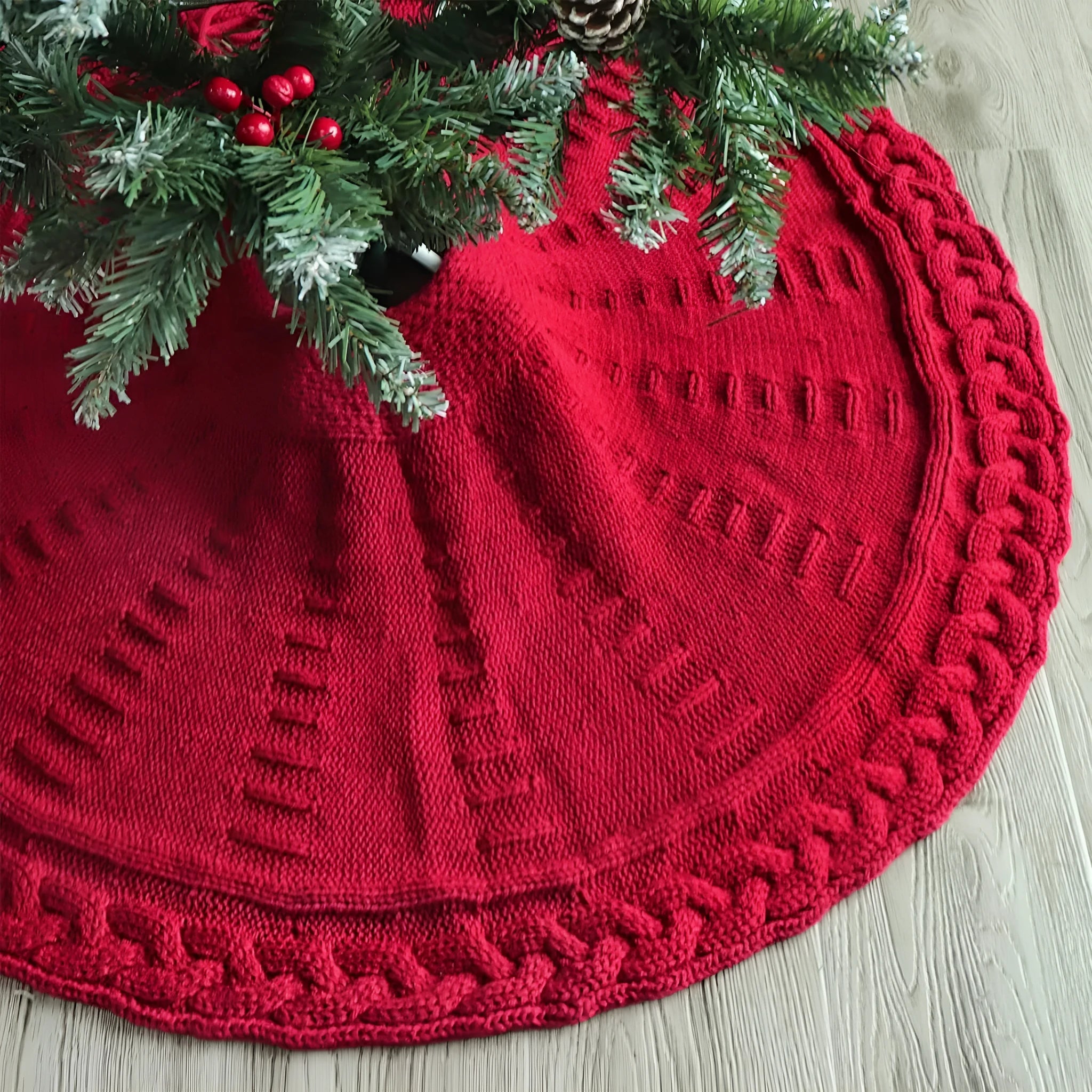 Red knitted wool Christmas tree skirt with 122cm diameter on floor under decorated tree