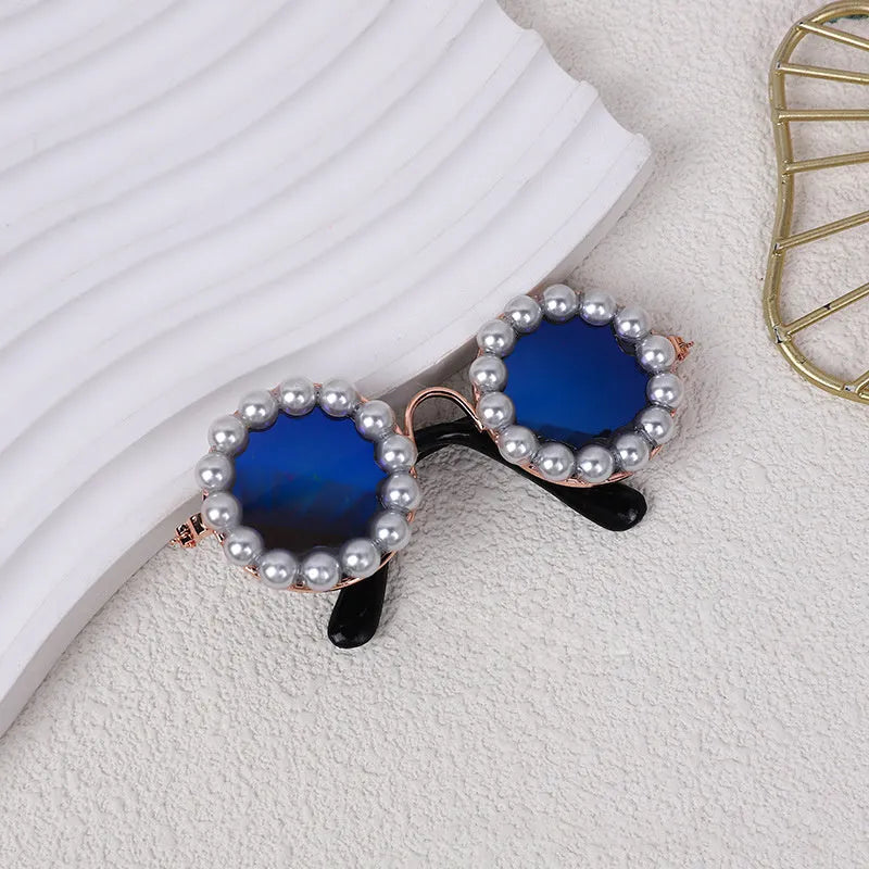 Pearl-rimmed round sunglasses on a cat or dog, shown in blue, black, coffee, orange, and purple colour options.