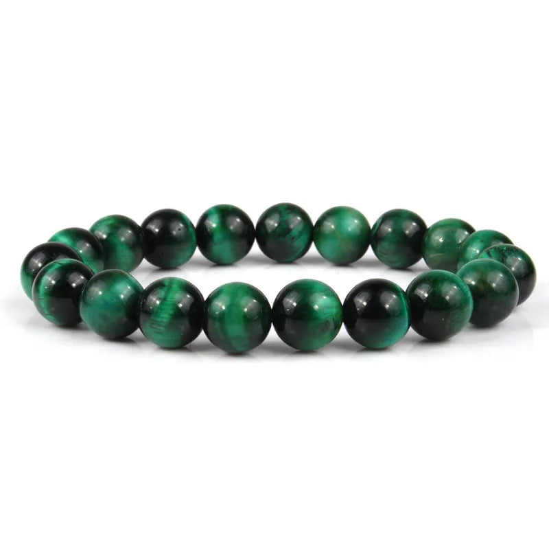 Natural tiger eye crystal bracelet with round beads in various colours on a wrist.