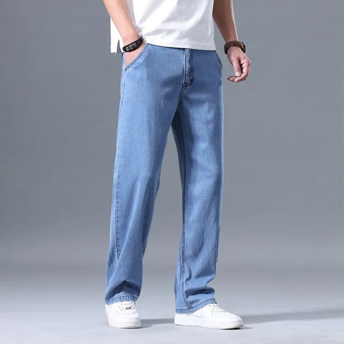 Man wearing light blue loose straight-leg lyocell jeans with a zipper fly.