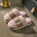 Women's beige plush slipper with Velcro strap and non-slip plastic sole on a wooden floor.