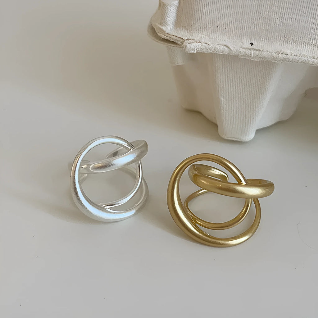 Geometric open ring with interlaced design in matte gold metal finish