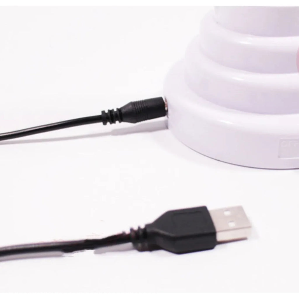 White bamboo-shaped desktop lamp emitting green light with USB power cable