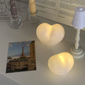 Small pink vinyl atmosphere lamp glowing with warm light on a wooden surface.