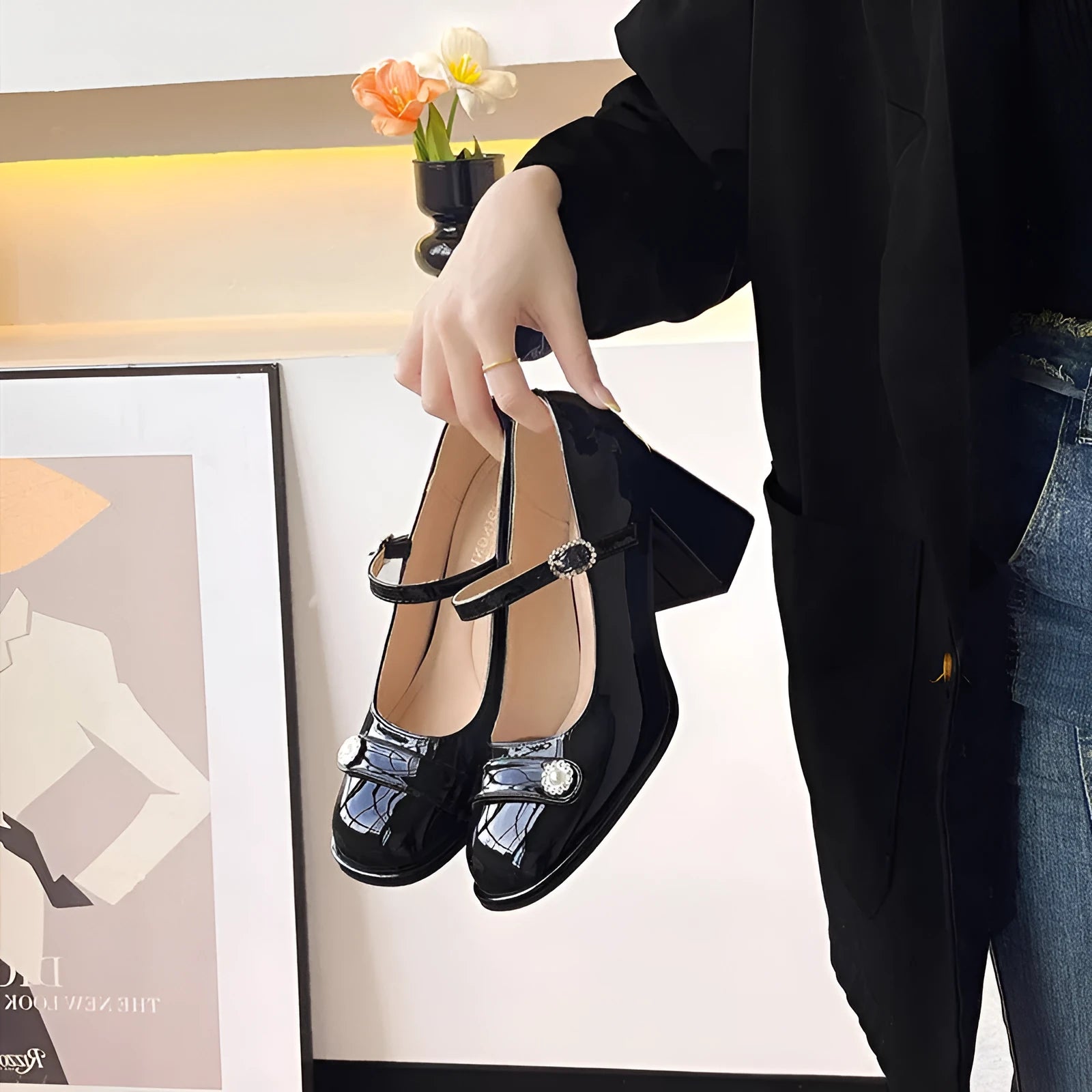 Women's black patent leather chunky heel shoes with round toe and buckle fastening.