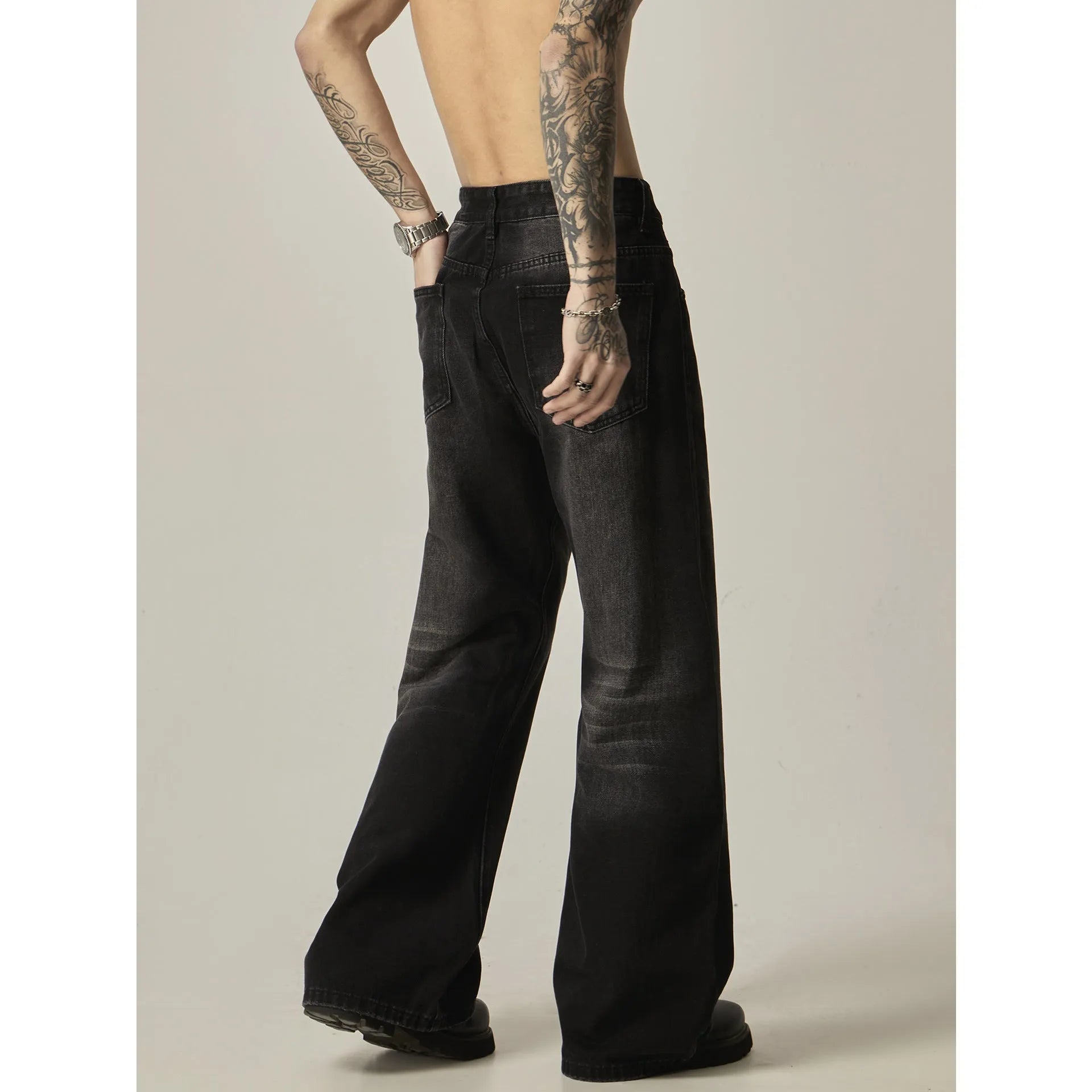 Black loose straight leg retro jeans on a hanger showing zipper fly detail