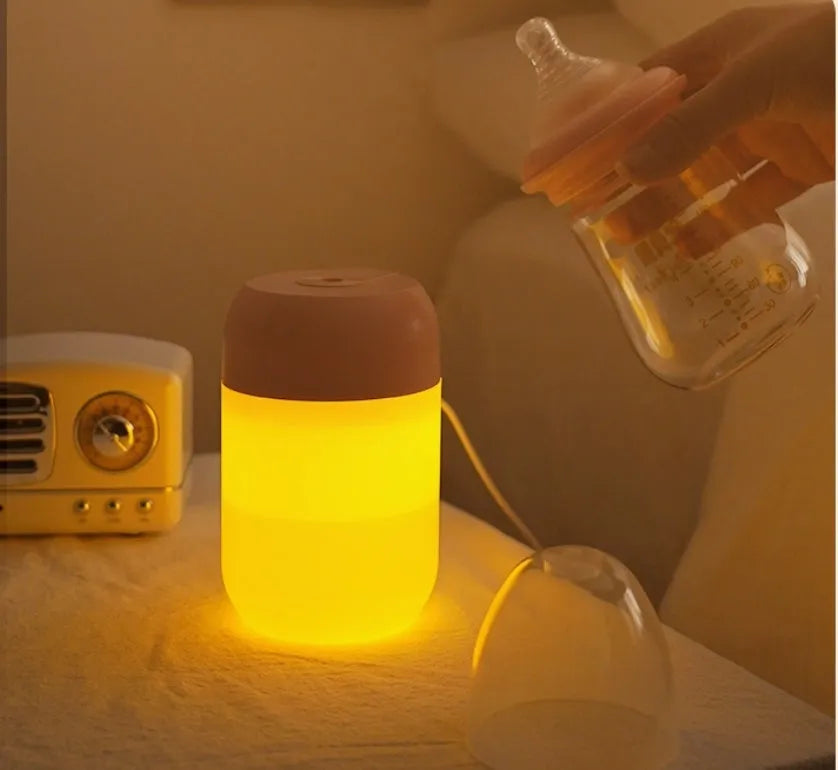 Small white cylindrical USB humidifier with aromatherapy function on a wooden desk.