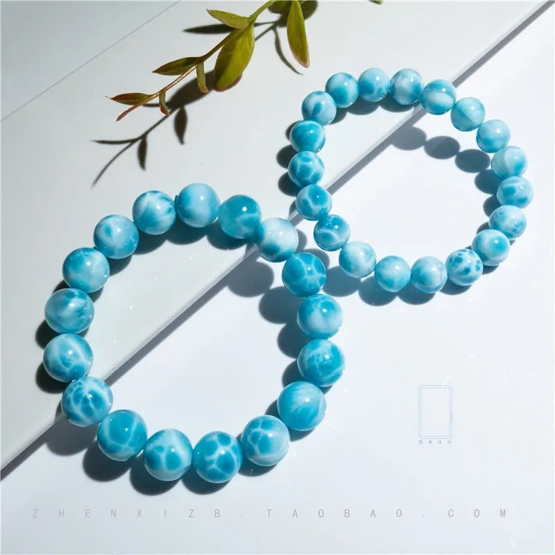 Blue handmade bodhi bracelet with natural crystal sea-pattern beads and pearl accents on a white background.