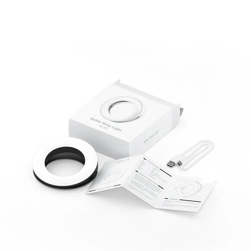 Compact black selfie ring light for mobile phone with USB cable for charging.