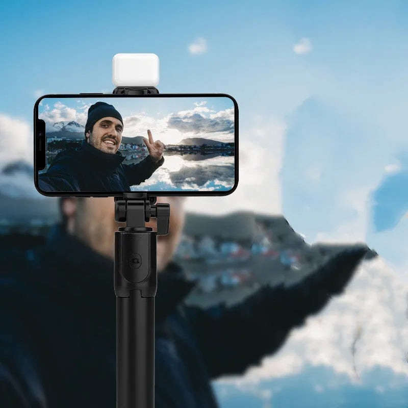 Black aluminium Bluetooth selfie stick tripod with integrated fill light and 360-degree rotating phone holder.