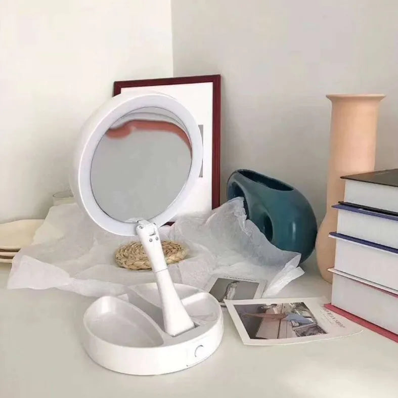 White foldable LED vanity mirror with USB charging port and built-in storage compartments on a table.