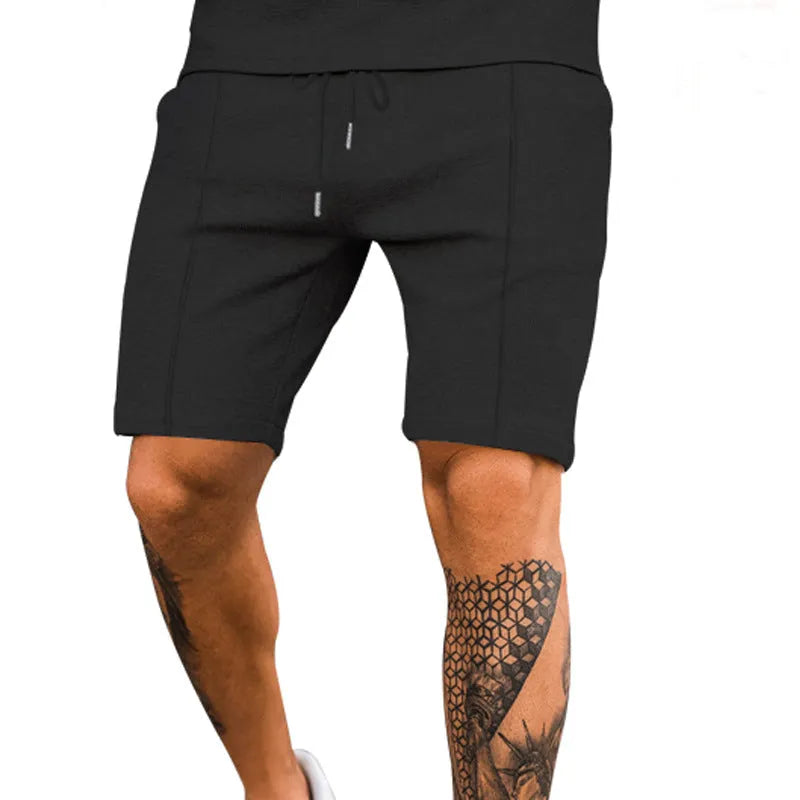 Solid colour polyester five-point sports shorts in Khaki, side view, showing elastic waist and above-knee length
