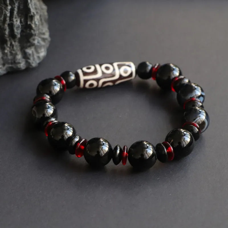 Hand-woven black agate dzi bead bracelet with geometric design measuring 11mm diameter