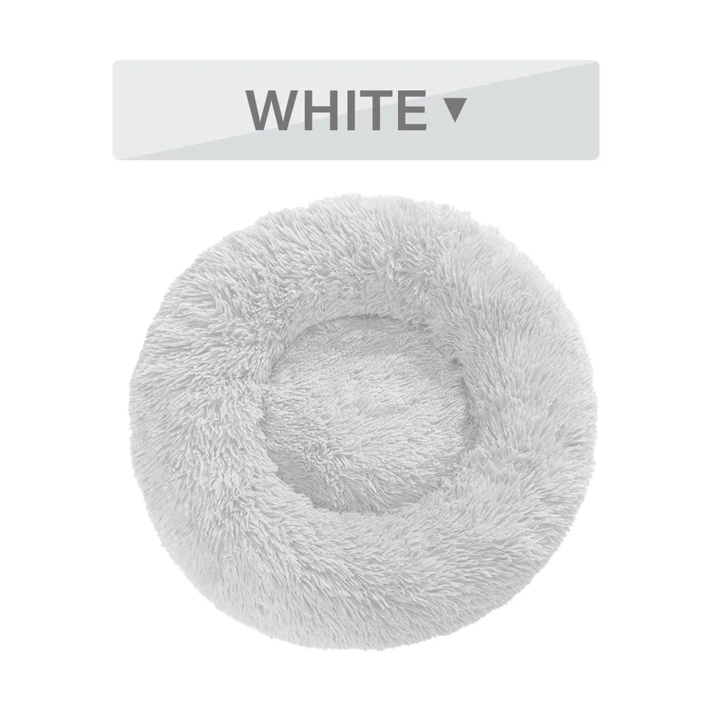 Fluffy donut-shaped pet bed in long plush material, showing raised edge and central well.
