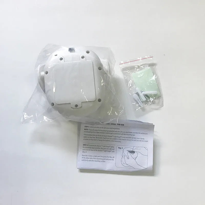 White Atomic Angel induction desk lamp with compact ABS plastic housing on a desk.