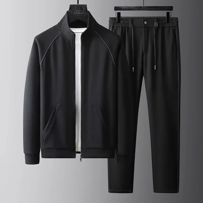Man wearing a slim fit black stand collar sports suit with long sleeves and matching trousers.