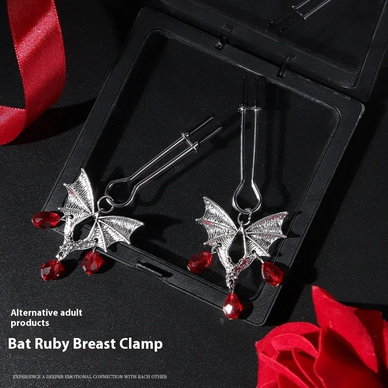 Silver bat-shaped nipple clamp with ruby accent detail and adjustable pressure mechanism