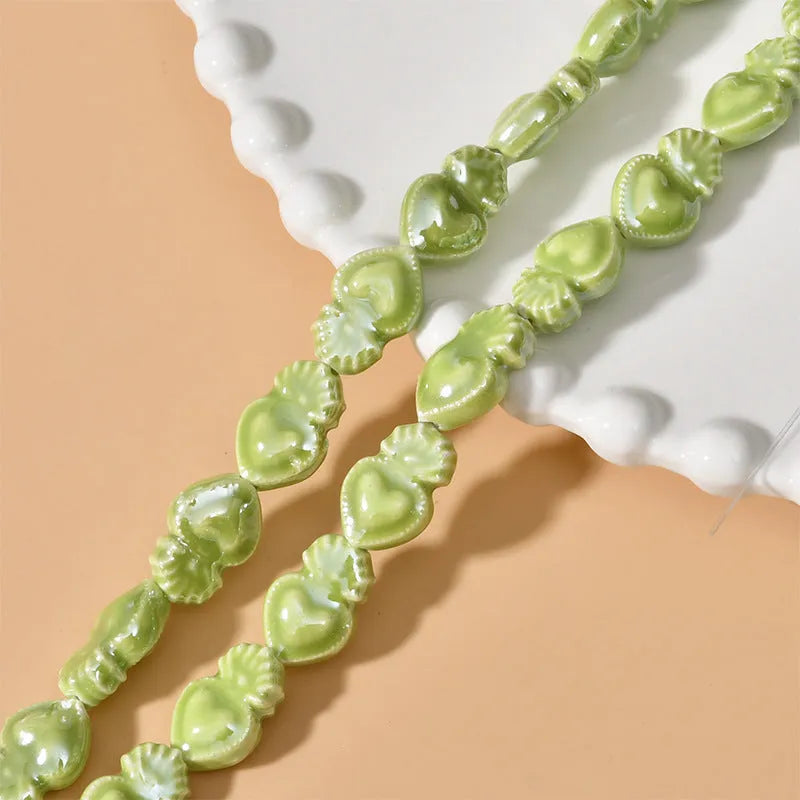Assorted small ceramic torch beads in multiple colours on a white background.