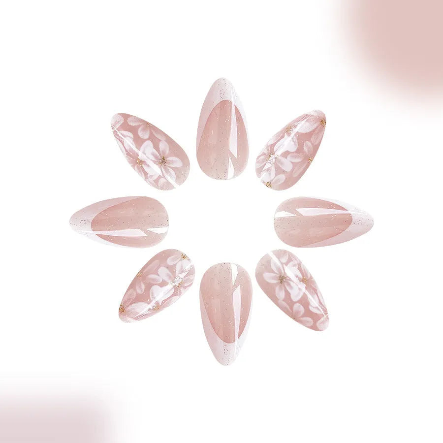 Short almond-shaped false nails with French tips and glitter powder flower decoration