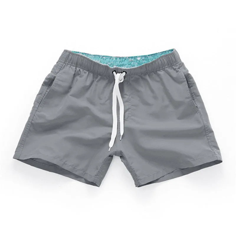 Men's black polyester beach shorts with a straight leg, shown on a size chart with options up to 4XL.