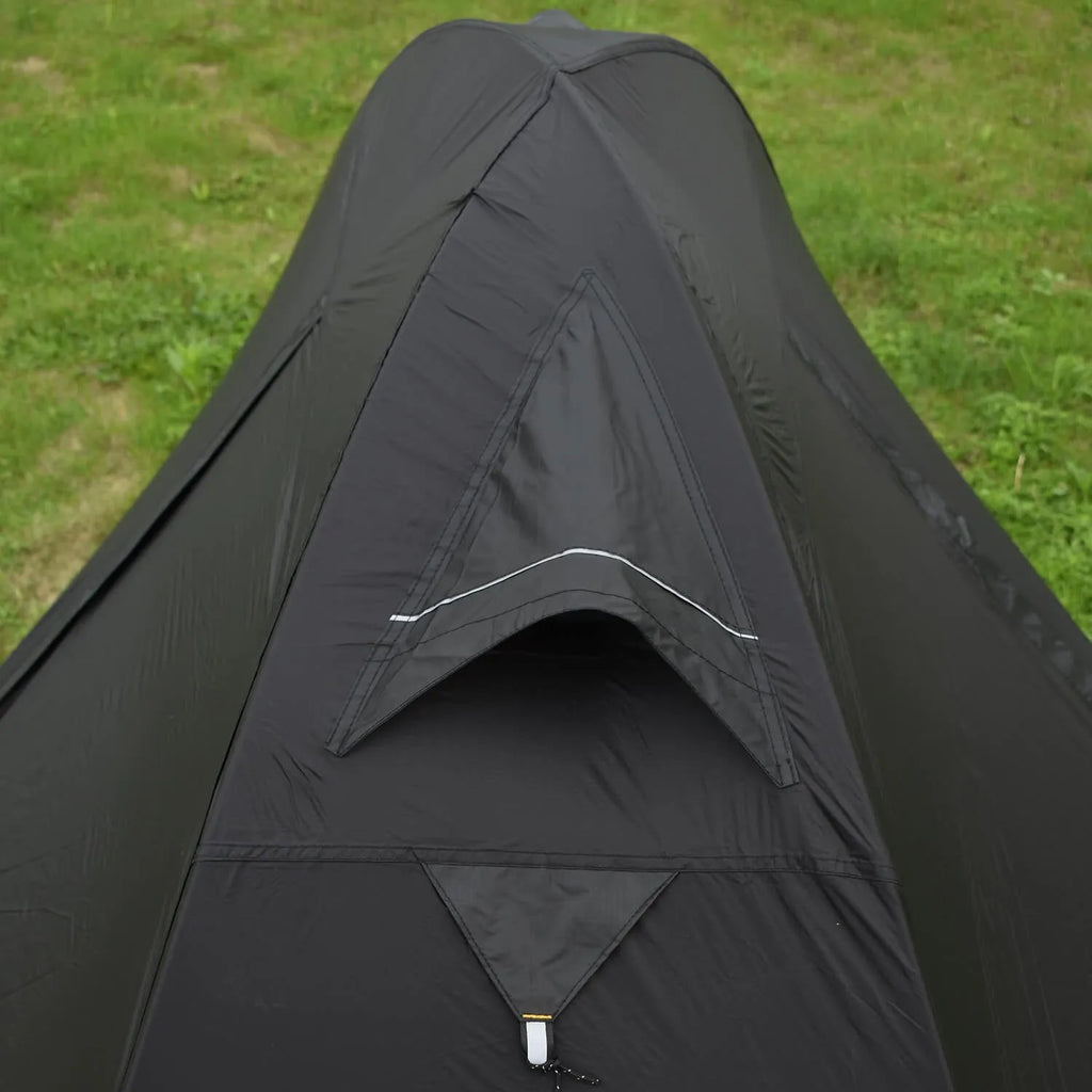 Black single person hiking tent with aluminium poles pitched outdoors, showing double-layer design.