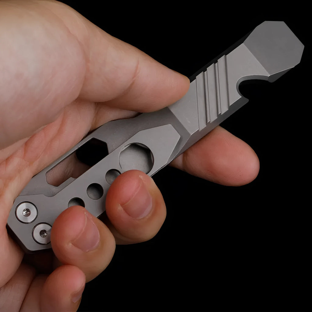 Titanium alloy multi-function crowbar tool with integrated bottle opener in gun grey or stone wash finish.