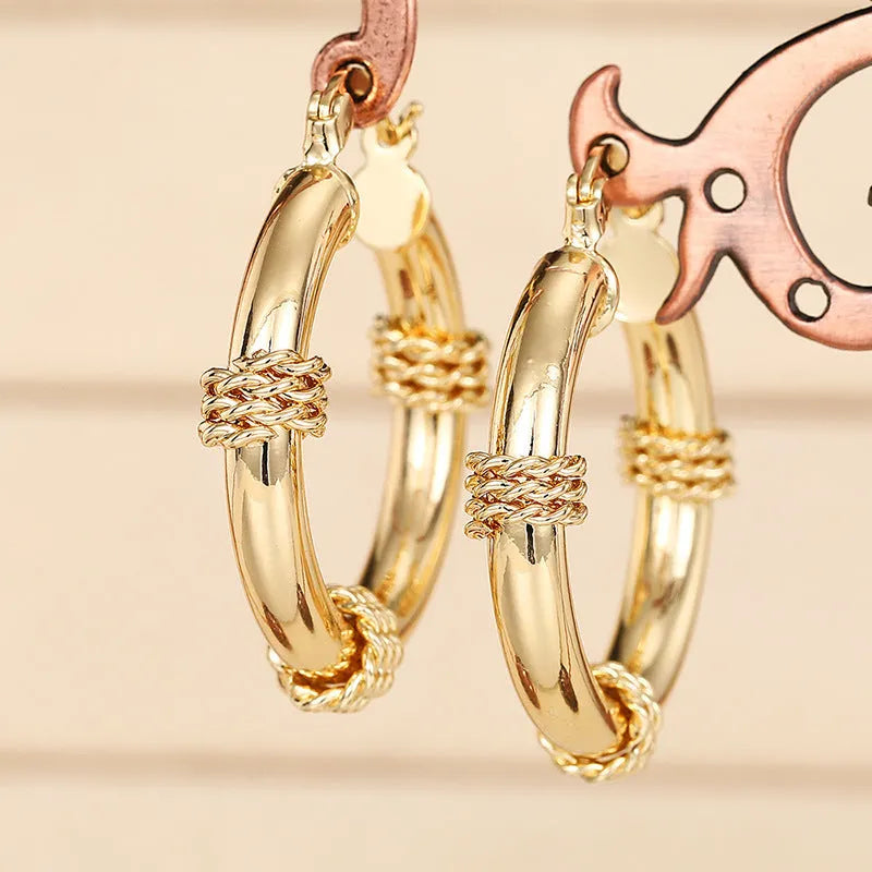 Women's geometric copper earrings with ring and line design elements in golden colours