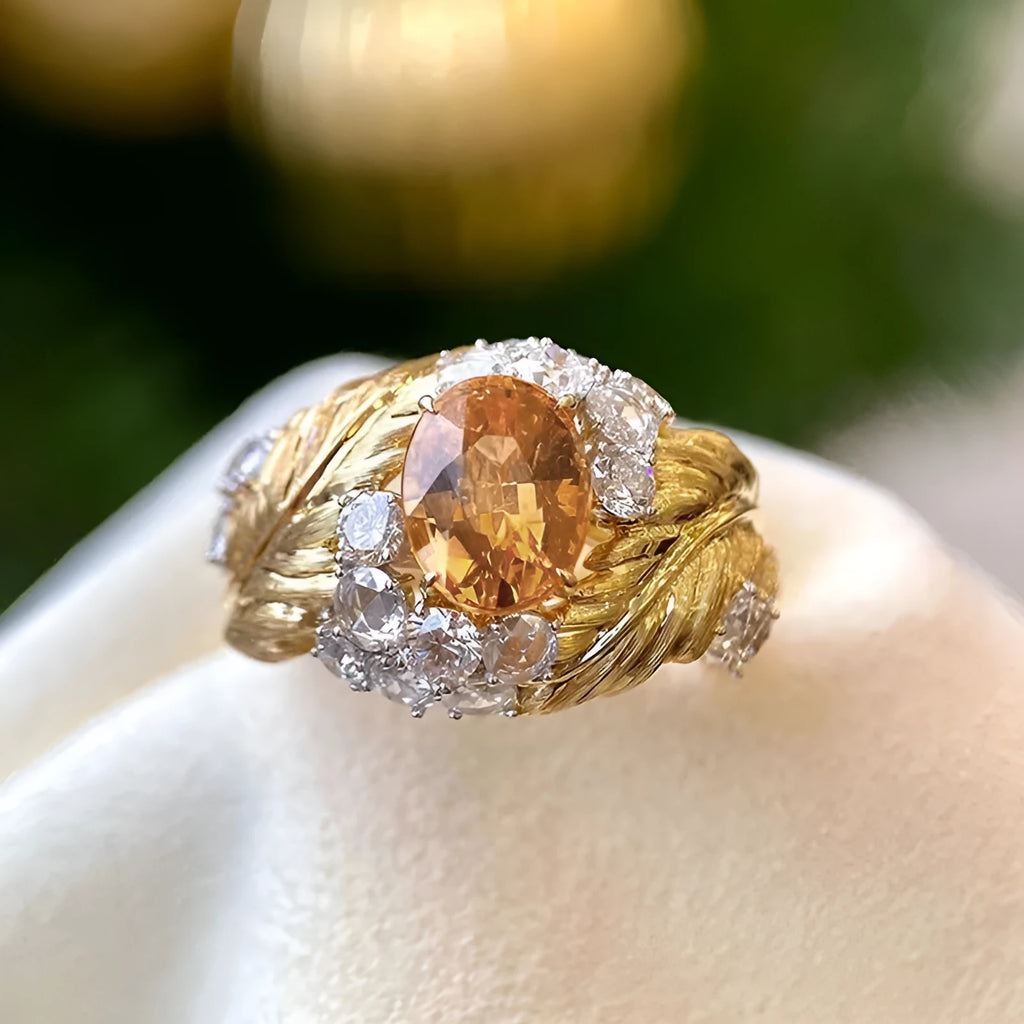 Gold coloured women's ring with embossed feather design and yellow zircon stones.