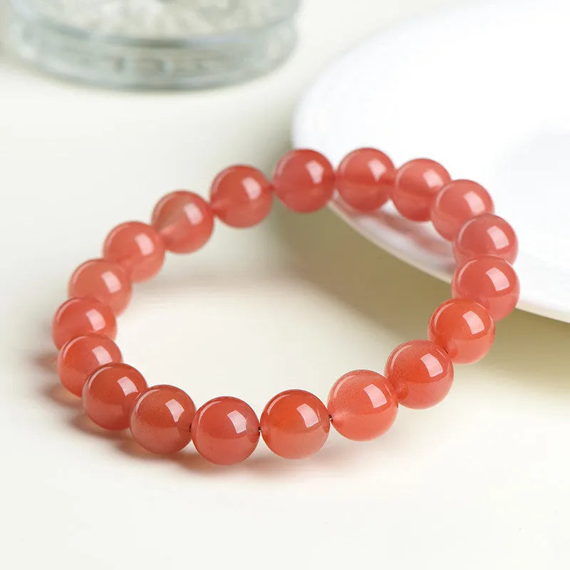 Natural South Cherry Red Agate polished bead bracelet shown in a scattered design on a wrist.