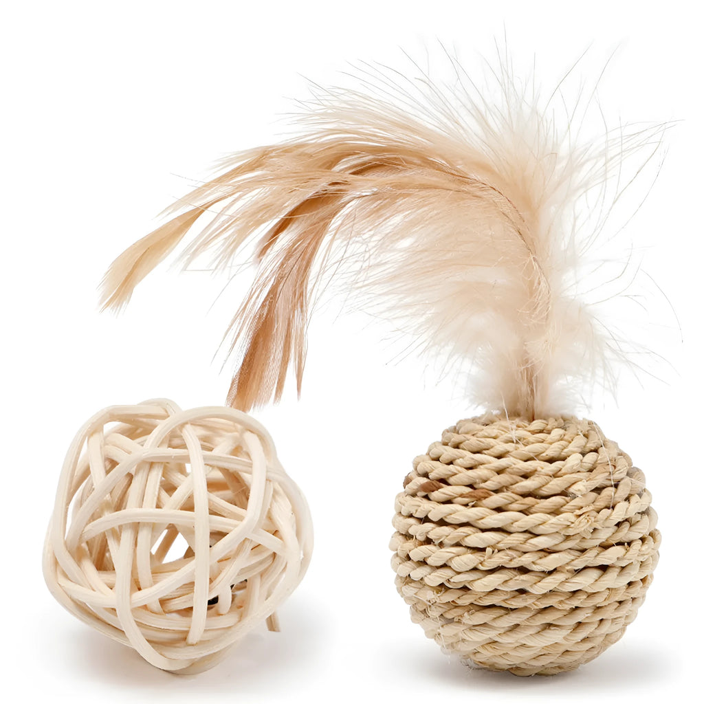 Two cat toys: a faux feather bell ball and a hollow rattan ball on a plain background.