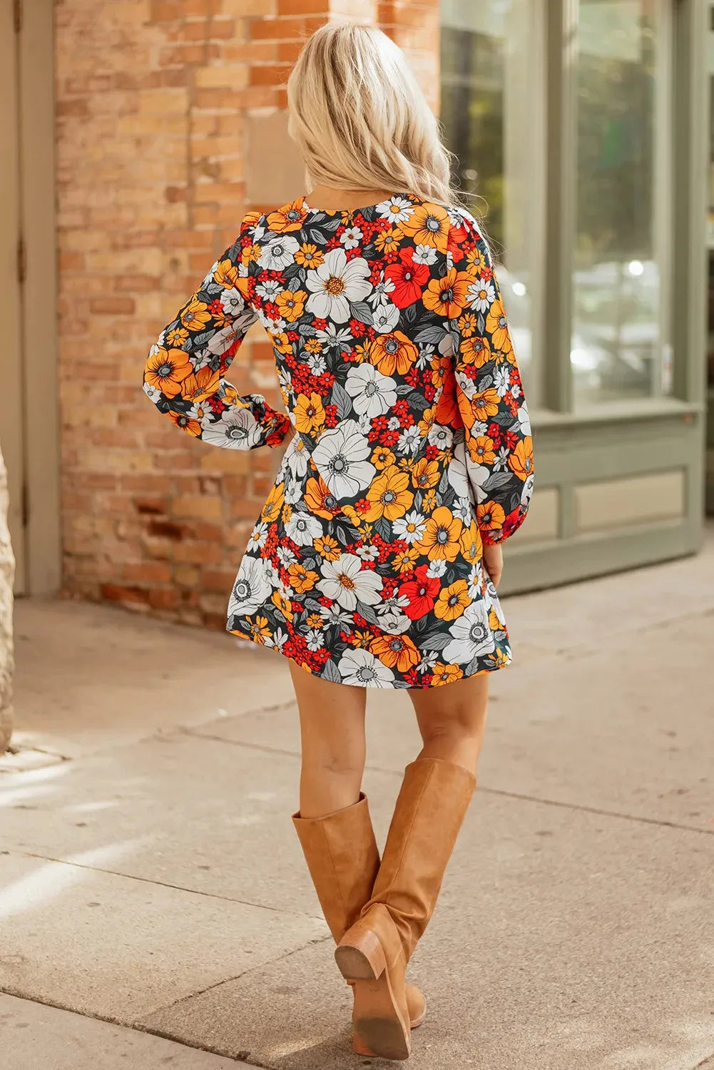 Orange floral print and striped lace V-neck long sleeve mini dress on a hanger.