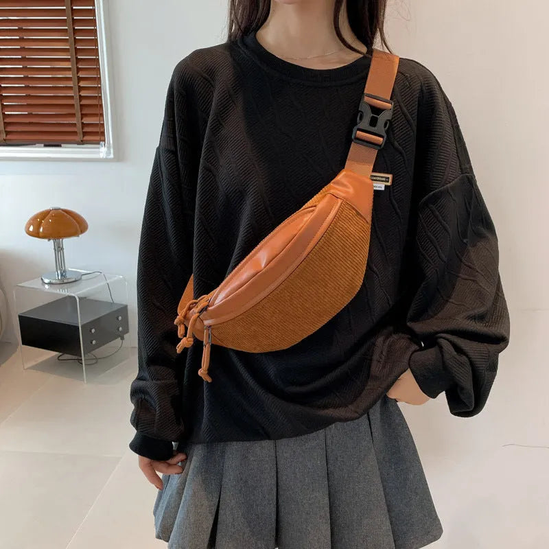 Corduroy crossbody bag in oval shape with brown colour, slit outer pocket, and crossbody strap for daily use