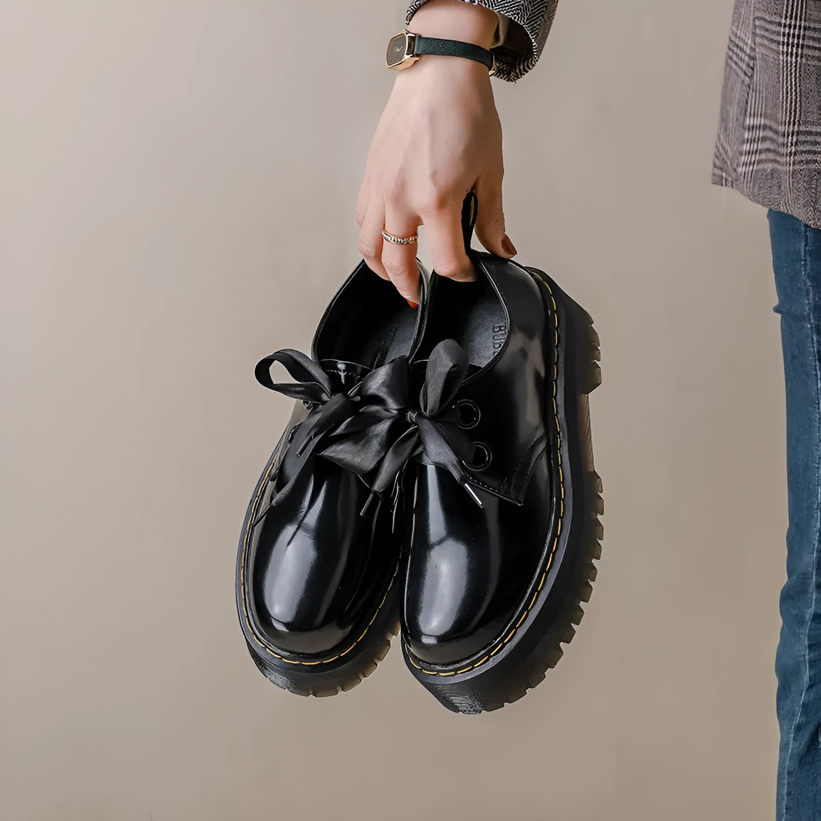 Women's thick-soled black shoes with cross strap and ribbon detail, lace-up closure