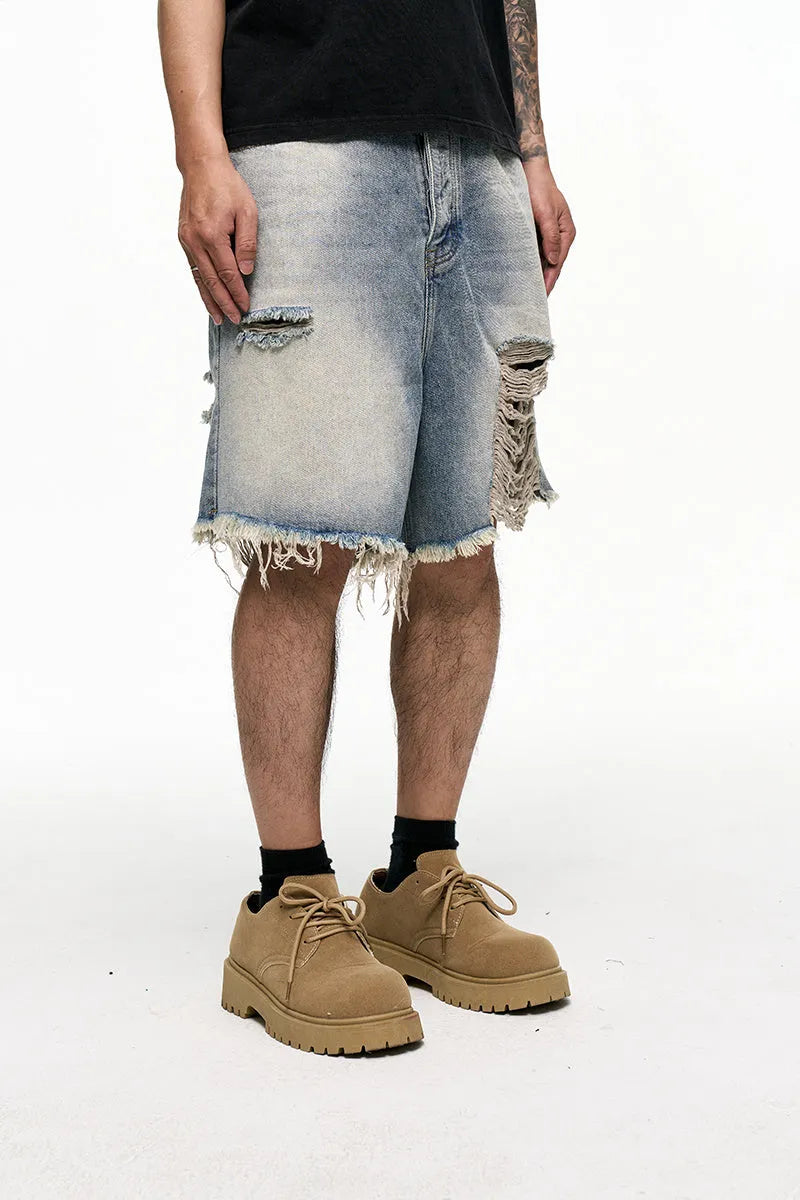 Light blue men's baggy denim shorts with a washed finish and zipper fly on a mid waist.