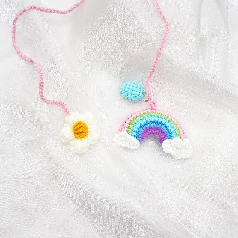Handmade crocheted rainbow flower car pendant in wool yarn with avocado, pink, and red colour options