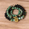 Green and black elastic beaded alloy bracelet on a wrist.