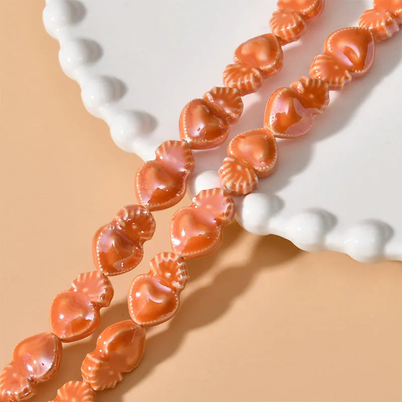 Assorted small ceramic torch beads in multiple colours on a white background.