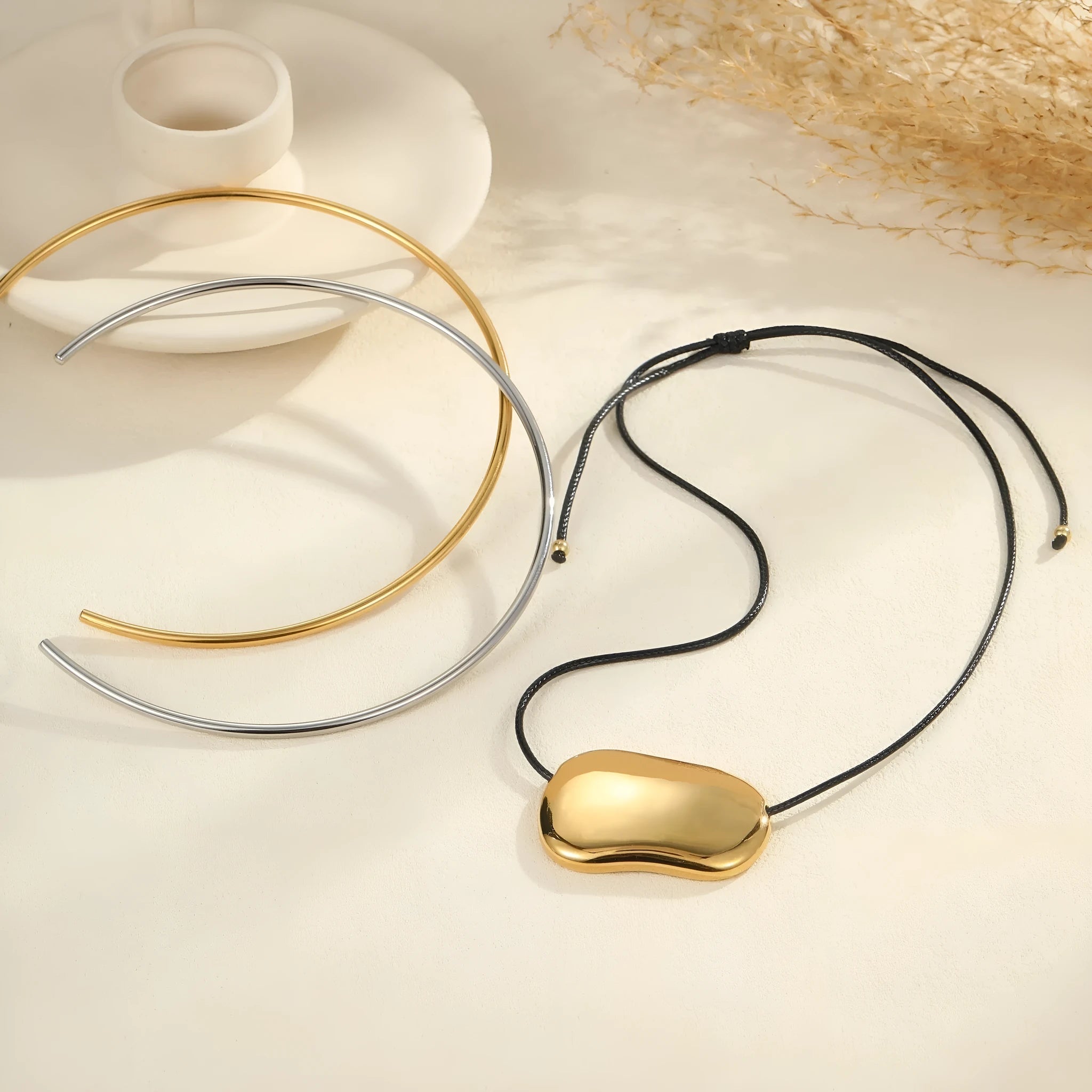 Titanium steel rope necklace with irregular geometry pendants in gold or silver finish on model