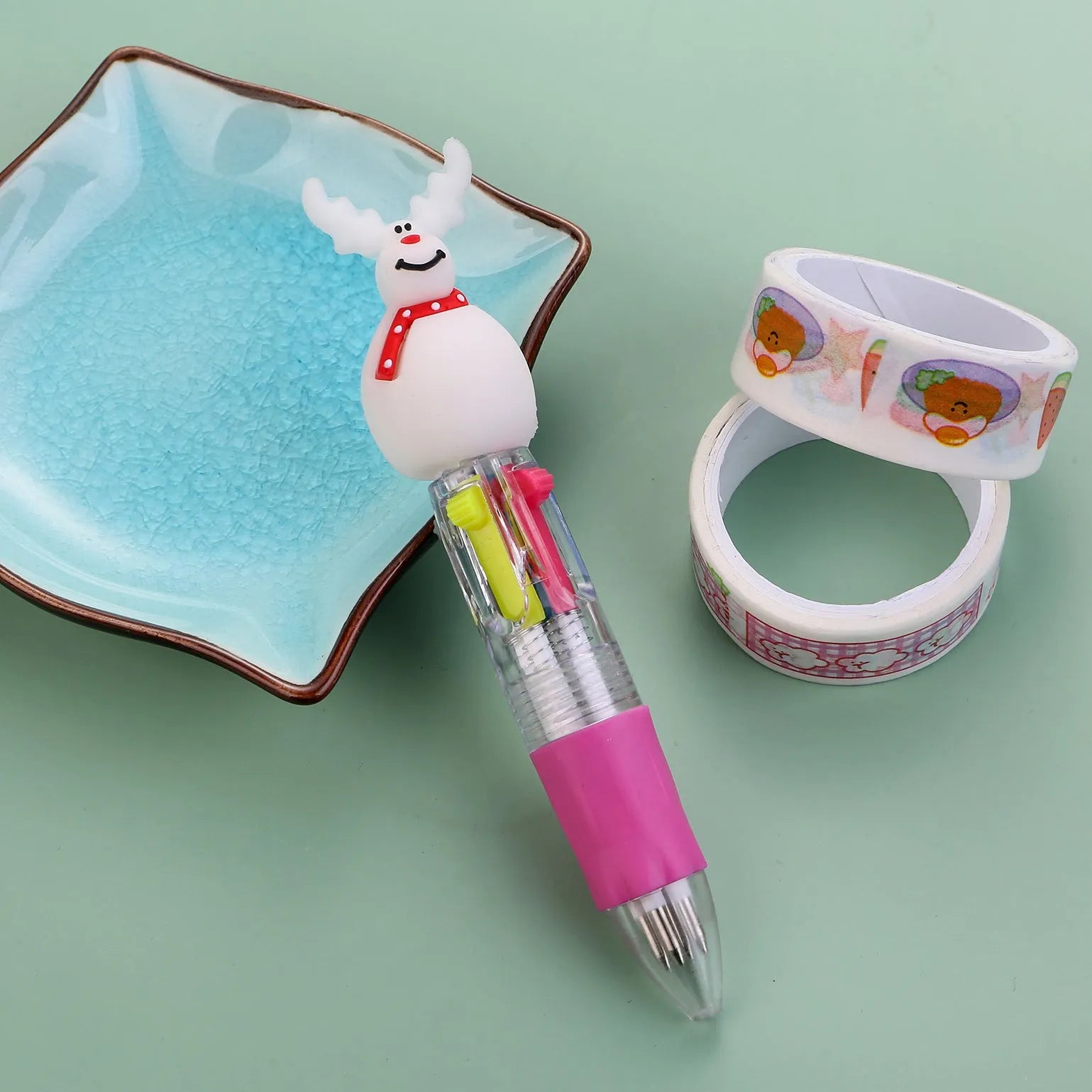 11cm long Christmas-themed four-colour ballpoint pen showing festive designs like reindeer and trees.