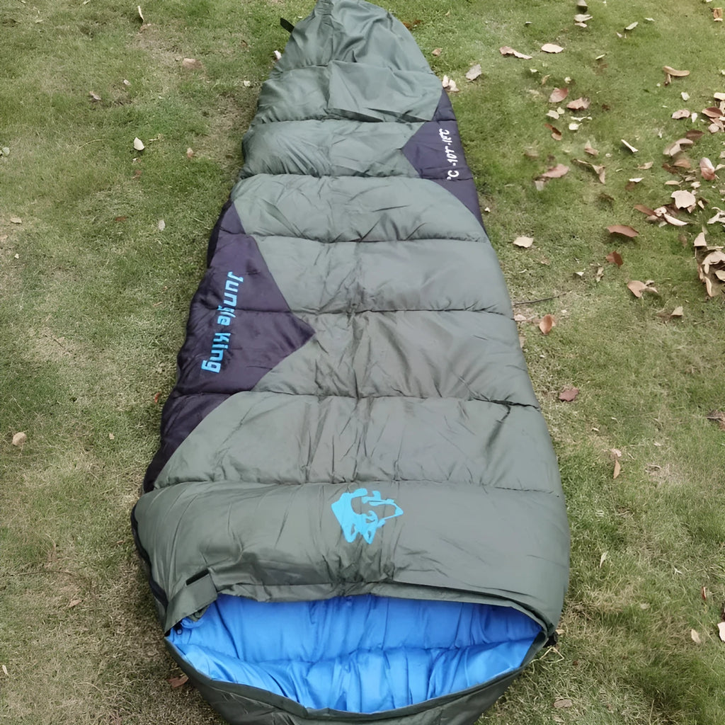 Outdoor cotton sleeping bag in Army Green, shown beside its grey compression storage sack.