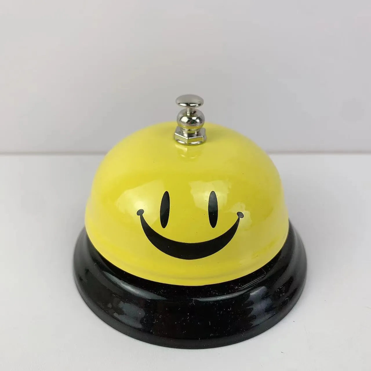 Iron hand bell with handle in one of eleven available colours, including red, green, blue, and pink.