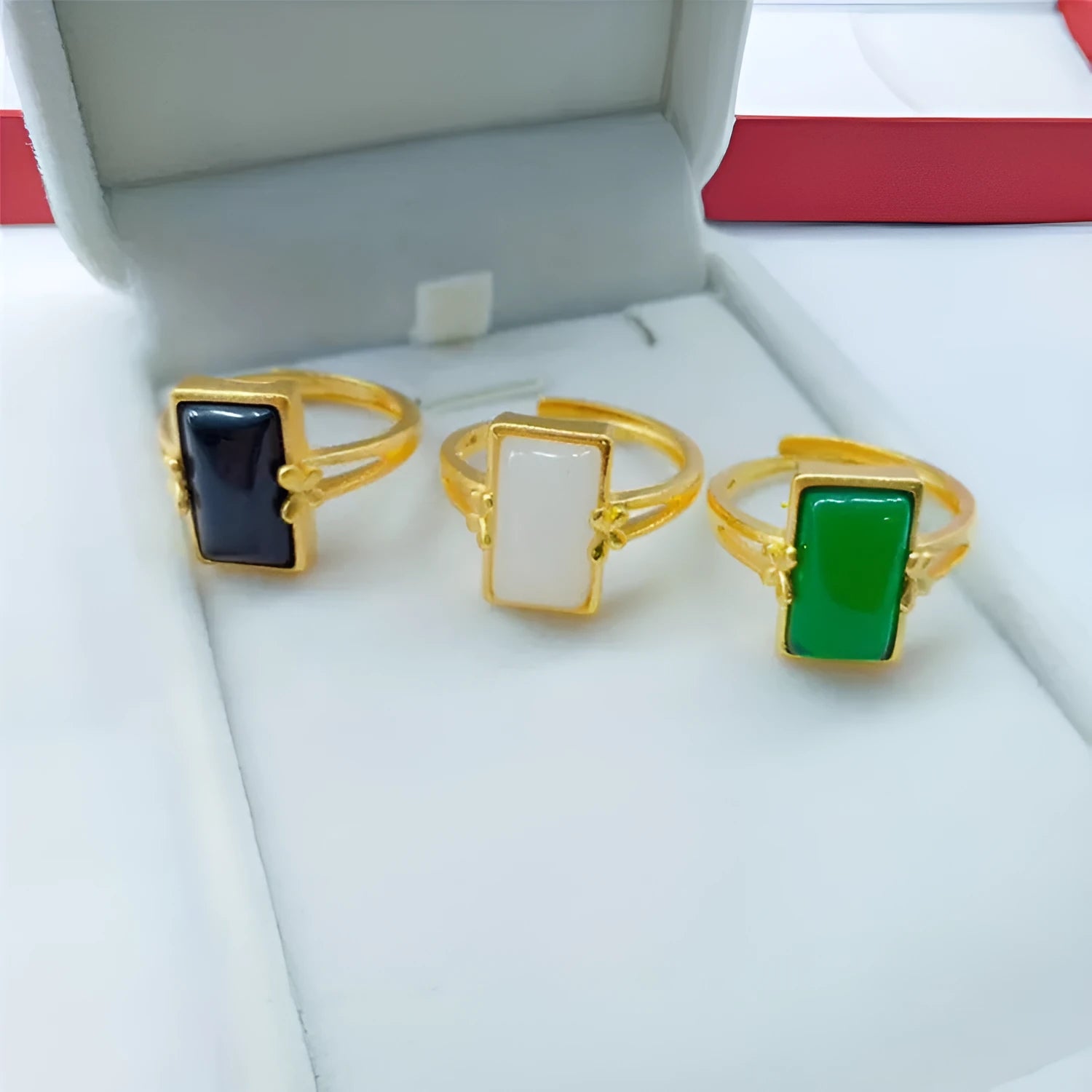 Adjustable gold-plated brass ring with a black gemstone inlay on a model's hand.