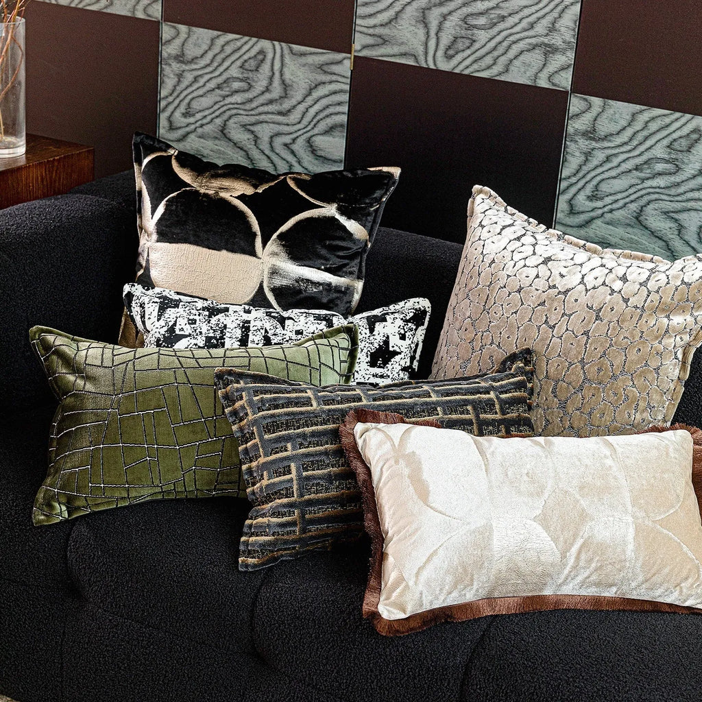 Black and gold abstract pattern decorative cushion cover on a grey sofa.