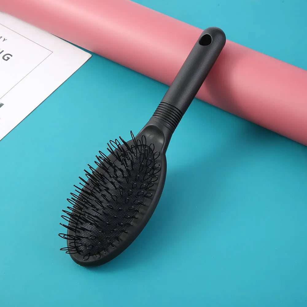 Black ring tooth hair extension comb with airbag cushion handle on white background