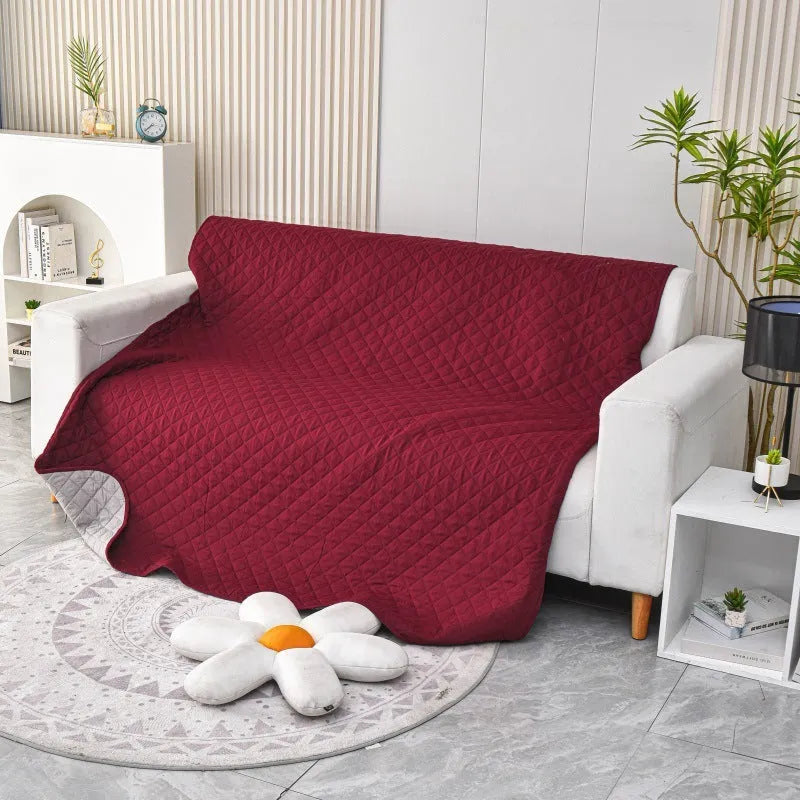 Waterproof reversible dog blanket on a sofa, showing two colour sides, with size chart for nine options.